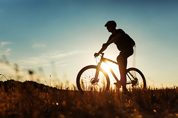 Image showing Man Cyclist with bike on sunset