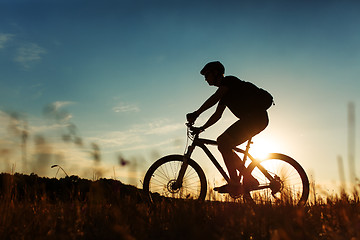 Image showing Man Cyclist with bike on sunset