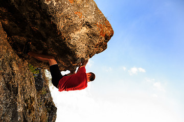 Image showing Young man climbing on a wall