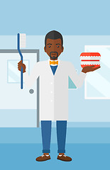 Image showing Dentist with dental jaw model and toothbrush.