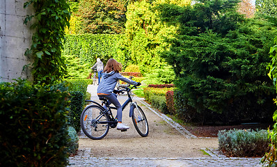 Image showing Father and daughter enjoy riding on bikes in park