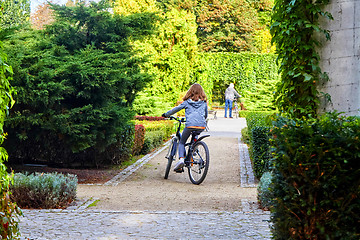 Image showing Father and daughter enjoy riding on bikes in park