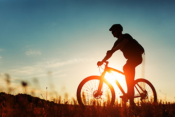 Image showing Man Cyclist with bike on sunset