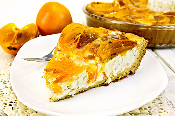 Image showing Pie with curd and persimmons in white plate on napkin silicone