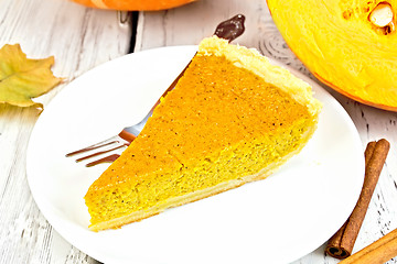 Image showing Pie pumpkin in plate with cinnamon on board