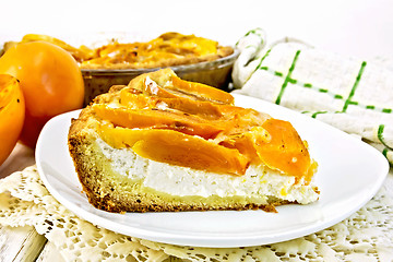 Image showing Pie with curd and persimmons in plate on napkin