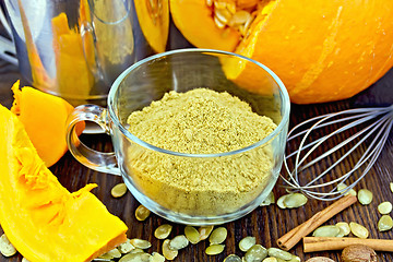 Image showing Flour pumpkin in glass cup with seeds and sieve on board