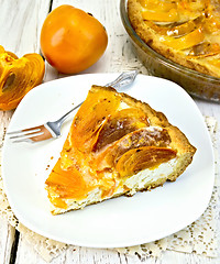 Image showing Pie with curd and persimmons in plate on napkin silicone