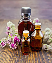 Image showing Oil with burdock in bottled on board