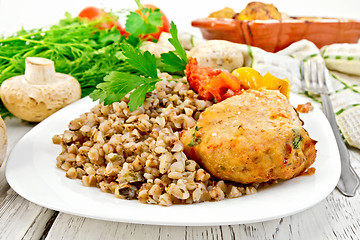 Image showing Cutlets of turkey with buckwheat and mushrooms in plate on board