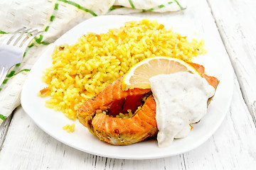 Image showing Salmon with lemon and rice on board