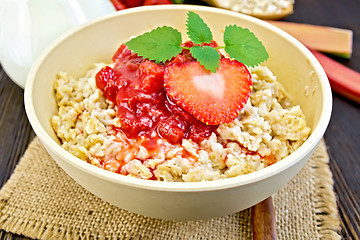 Image showing Oatmeal with strawberry-rhubarb sauce on dark board