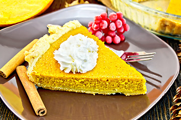 Image showing Pie pumpkin in plate with cream on dark board