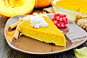 Image showing Pie pumpkin in brown plate with cream on dark board