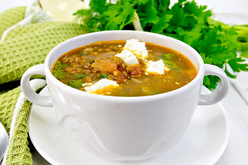 Image showing Soup lentil with spinach and cheese in white bowl on board
