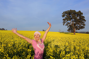 Image showing Happy woman in field of golden canola