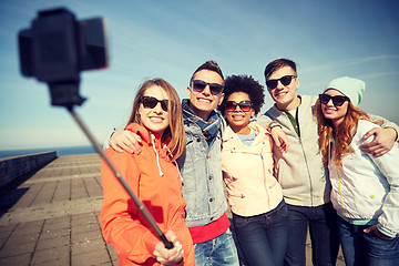 Image showing smiling friends taking selfie with smartphone