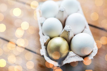 Image showing close up of white and gold eggs in egg box