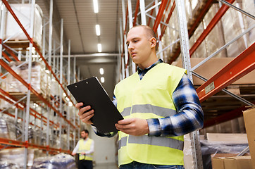 Image showing man with clipboard in safety vest at warehouse