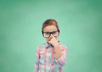 Image showing happy little girl in eyeglasses over school board