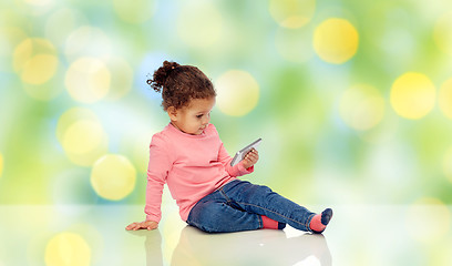 Image showing smiling little baby girl playing with smartphone