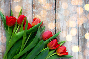 Image showing close up of red tulips on wooden background