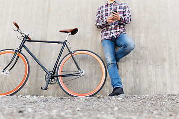 Image showing close up of hipster man with smartphone and bike