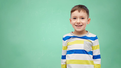 Image showing happy smiling little boy over green school board