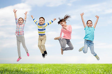 Image showing happy children jumping in air over sky and grass