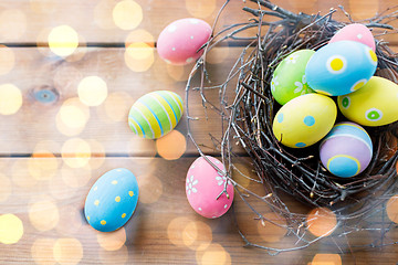 Image showing close up of colored easter eggs in nest on wood