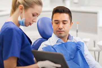 Image showing female dentist with tablet pc and male patient