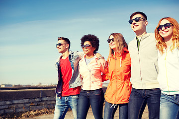 Image showing happy teenage friends walking along city street