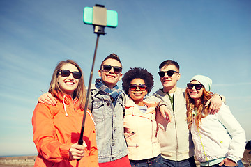 Image showing smiling friends taking selfie with smartphone