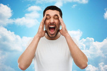 Image showing crazy shouting man in t-shirt over blue sky