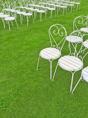 Image showing Empty white chairs on the green lawn