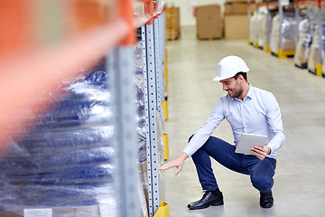 Image showing happy businessman with tablet pc at warehouse