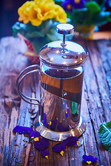 Image showing Flower tea in glass pot on a wooden table. 