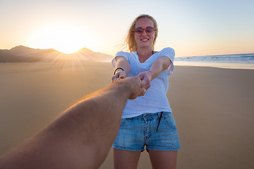 Image showing Romantic couple, holding hands, having fun on beach.