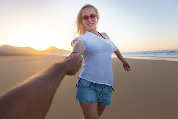 Image showing Romantic couple, holding hands, having fun on beach.