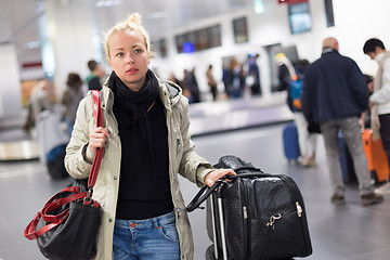 Image showing Female traveler transporting her luggage in airport terminal.