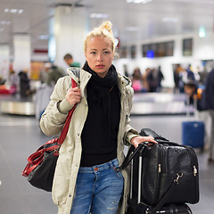 Image showing Female traveler transporting her luggage in airport terminal.