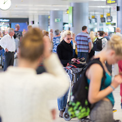 Image showing Female traveler using cell phone while waiting.