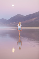 Image showing Lady walking on sandy beach in sunset.