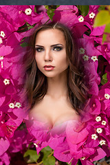 Image showing The beauty young woman with flowers of pink bougainvillea