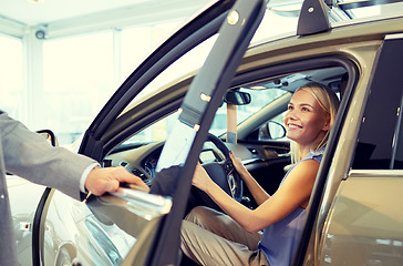 Image showing happy woman with car dealer in auto show or salon