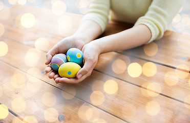 Image showing close up of woman hands with colored easter eggs