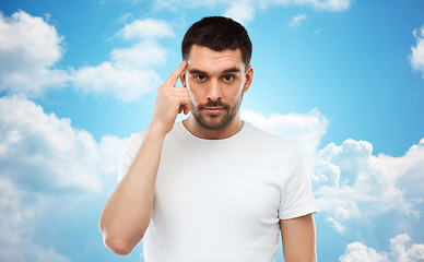 Image showing man with finger at temple over blue sky background