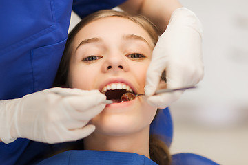 Image showing female dentist checking patient girl teeth