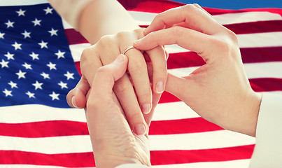 Image showing close up of lesbian couple hands with wedding ring