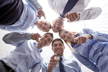 Image showing smiling group of businesspeople standing in circle